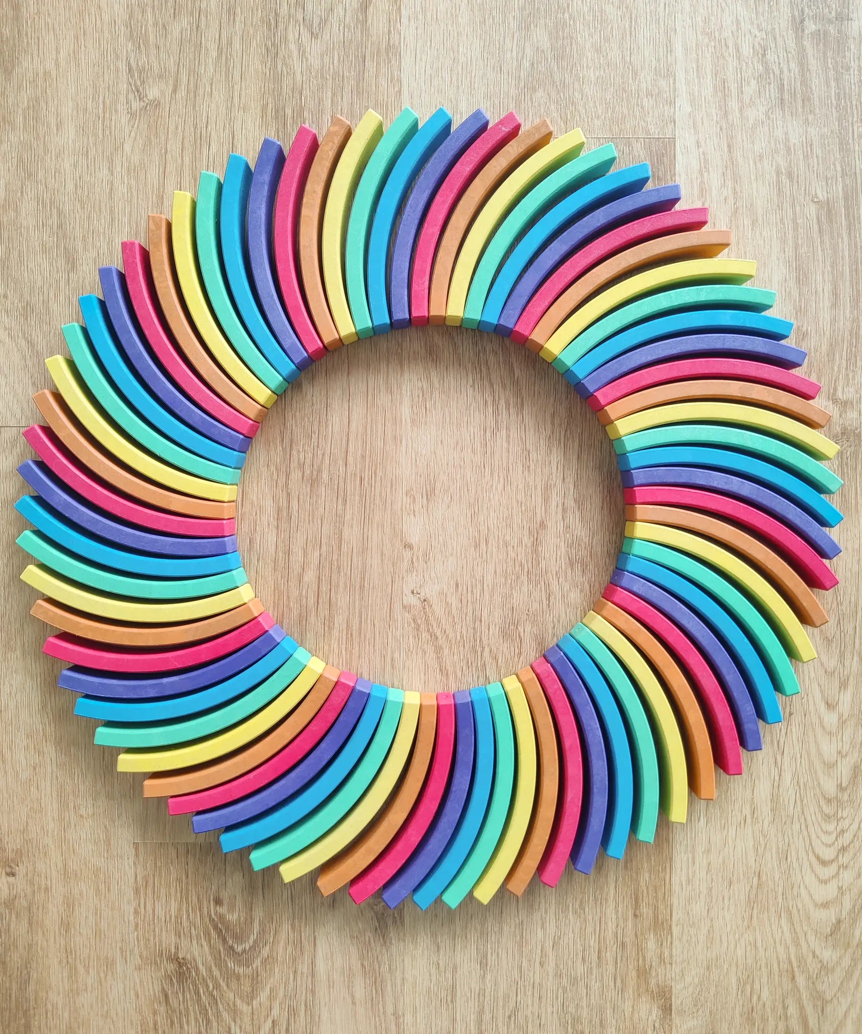 Abel blocks mini rewood Rainbow wooden stacking blocks placed in a circle.