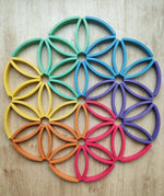 Abel blocks mini rewood Rainbow wooden stacking blocks placed on a wooden surface to form a mandala like pattern.