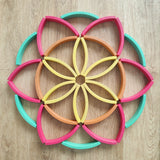 Abel blocks mini rewood Rainbow wooden stacking blocks placed in a flower like mandala pattern.