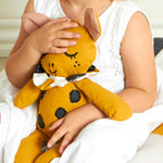 A child cuddling the Roommate Canvas Doll Goldy The Giraffe.
