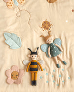Childrens Roommate eco-friendly soft rag doll bee and butterfly toy laying on a cream duvet set