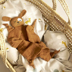 Roommate eco-friendly brown dog baby blanket laid out on a grey duvet in a moses basket