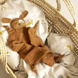 Roommate eco-friendly brown dog baby blanket laid out on a grey duvet in a moses basket