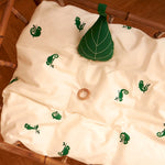 The Roommate Leaf Lullaby Music Mobile is attached to the inside of a crib, and is resting on a Roommate bed cover