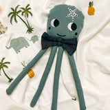 A Roommate octopus rag doll on a patterned duvet cover. 