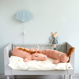 Roommate soft organic cotton long horse cushion laying on a childs bed