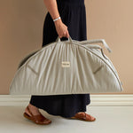Roommate Baby Gym in an Elephant design show folded up being carried by it's handle by an adult