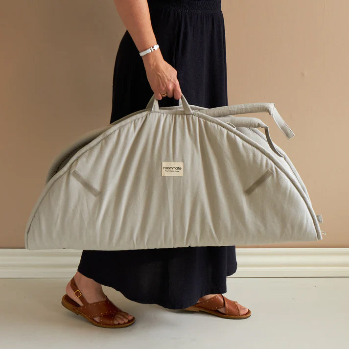 Roommate Baby Gym in an Elephant design show folded up being carried by it's handle by an adult
