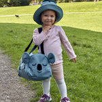 A child wearing the Roommate Koala bucket hat and carrying a koala bag.