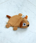 Roommate organic cotton dog washcloth bath toy shown alone on a light marble surface, highlighting the embroidered facial features, soft terry fabric, and hanging loop.