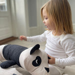 A child playing with the long roommate panda cushion