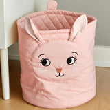 Roommate quilted basket with a pink bunny design placed on a wooden floor. 