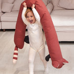 A child holding the Roommate red panda long cushion above the head while walking