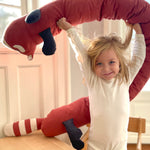A child holding the Roommate red panda cushion above the head 
