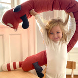 A child holding the Roommate red panda cushion above the head 