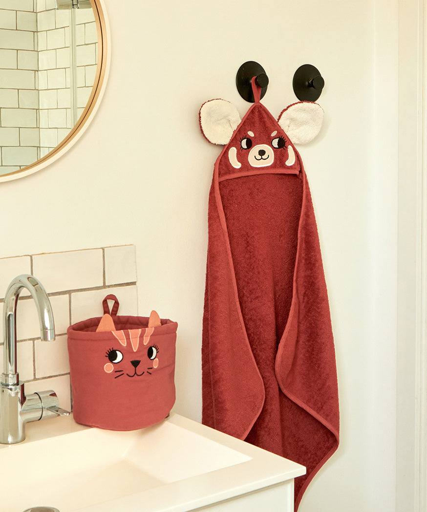 The Roommate kids red panda hooded towel, hanging in a bathroom. 