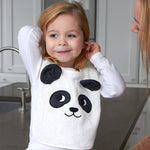 Child sat on a grey kitchen worktop wearing the Roommate Panda Baby Bib in organic cotton with embroidered panda face with 3D ears.