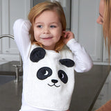 Child sat on a grey kitchen worktop wearing the Roommate Panda Baby Bib in organic cotton with embroidered panda face with 3D ears.