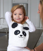 Child sat on a grey kitchen worktop wearing the Roommate Panda Baby Bib in organic cotton with embroidered panda face with 3D ears.