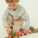 A child holding the Oli & Carol 100% Natural Rubber Car collection