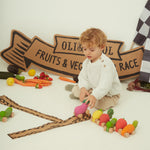 A child holding the Oli & Carol 100% Natural Rubber Car collection