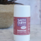 Salt Of The Earth refillable deodorant stick in natural lavender and vanilla on a marble surface with a plant in the background