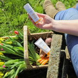 A person holding the Green People Natural and Organic Mineral Suncream SPF30 Scent Free bottle in their hand