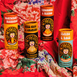 4 Scrubber plastic-free natural deodorant 
sticks with groovy packaging standing on a red floral cloth.