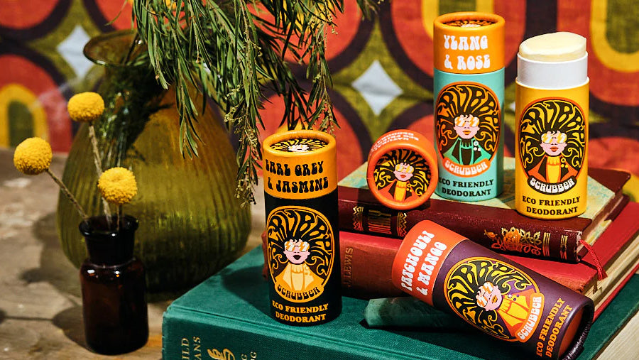 A collection of Scrubber natural deodorants in different scents, on some books.
