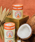 Two of the mango & coconut Scrubber natural powder dry shampoo in 100% recycled cardboard packaging in a retro display setup