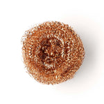 Close up of a Seep recyclable copper dishwashing scourer on a white background