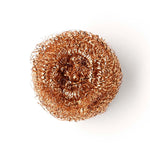 Close up of a Seep recyclable copper dishwashing scourer on a white background