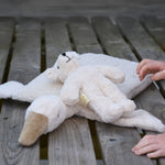 A Senger white baby bear placed on a A Senger goose pillow.