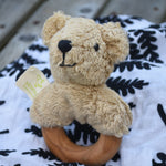 A Senger bear baby grasping toy placed on an Etta Loves fern print sensory muslin cloth.