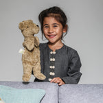 A child playing with a Senger beige bear Hand Puppet.