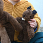 A close up of a Senger Baby Beaver Organic Soft Toy in a child's hands
