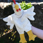 A close up of the Senger white chicken puppet in use on a child's hand.