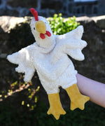 A close up of the Senger white chicken puppet in use on a child's hand.