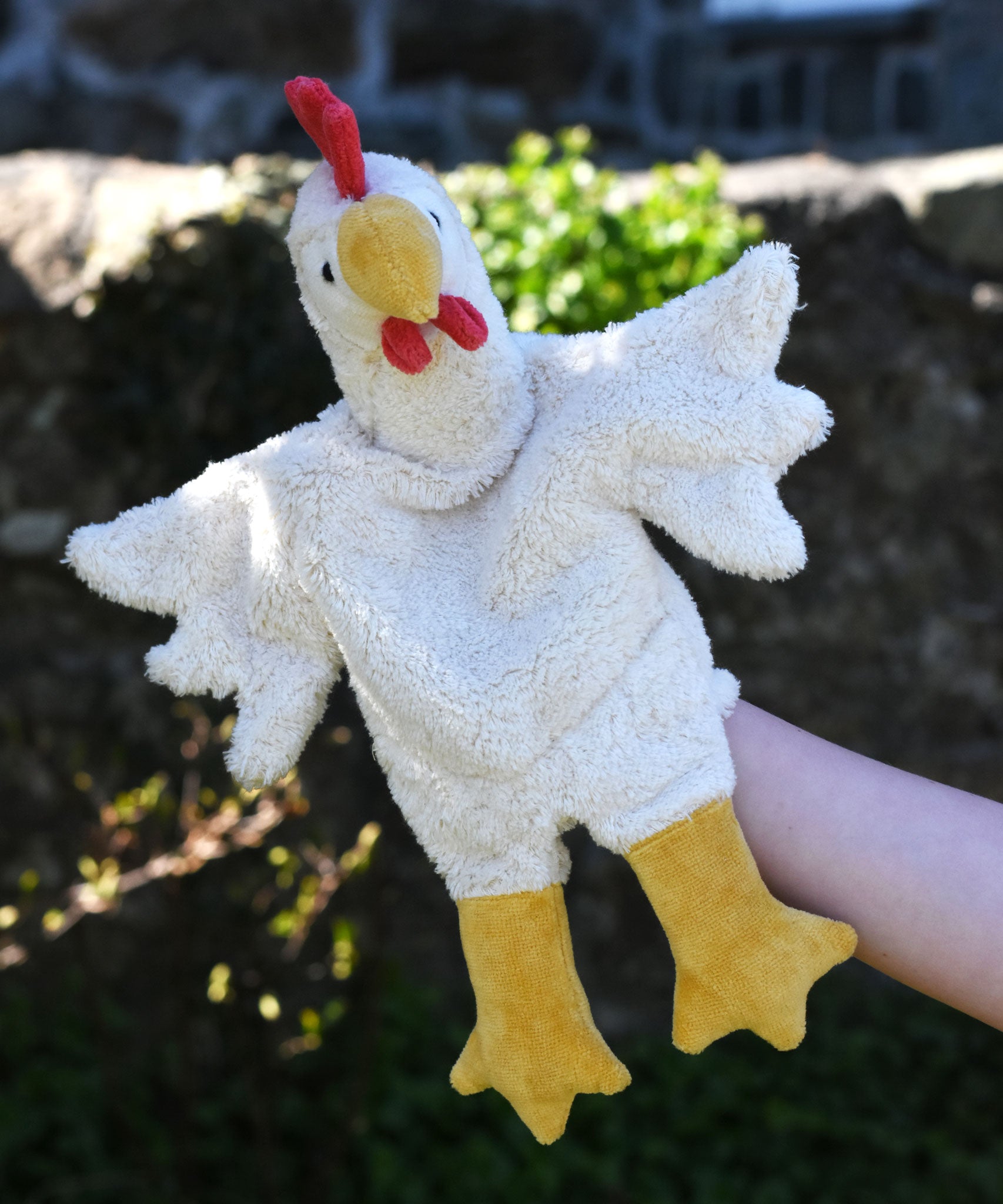 A close up of the Senger white chicken puppet in use on a child's hand.
