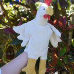 A close up of the Senger white chicken puppet in use on a child's hand.