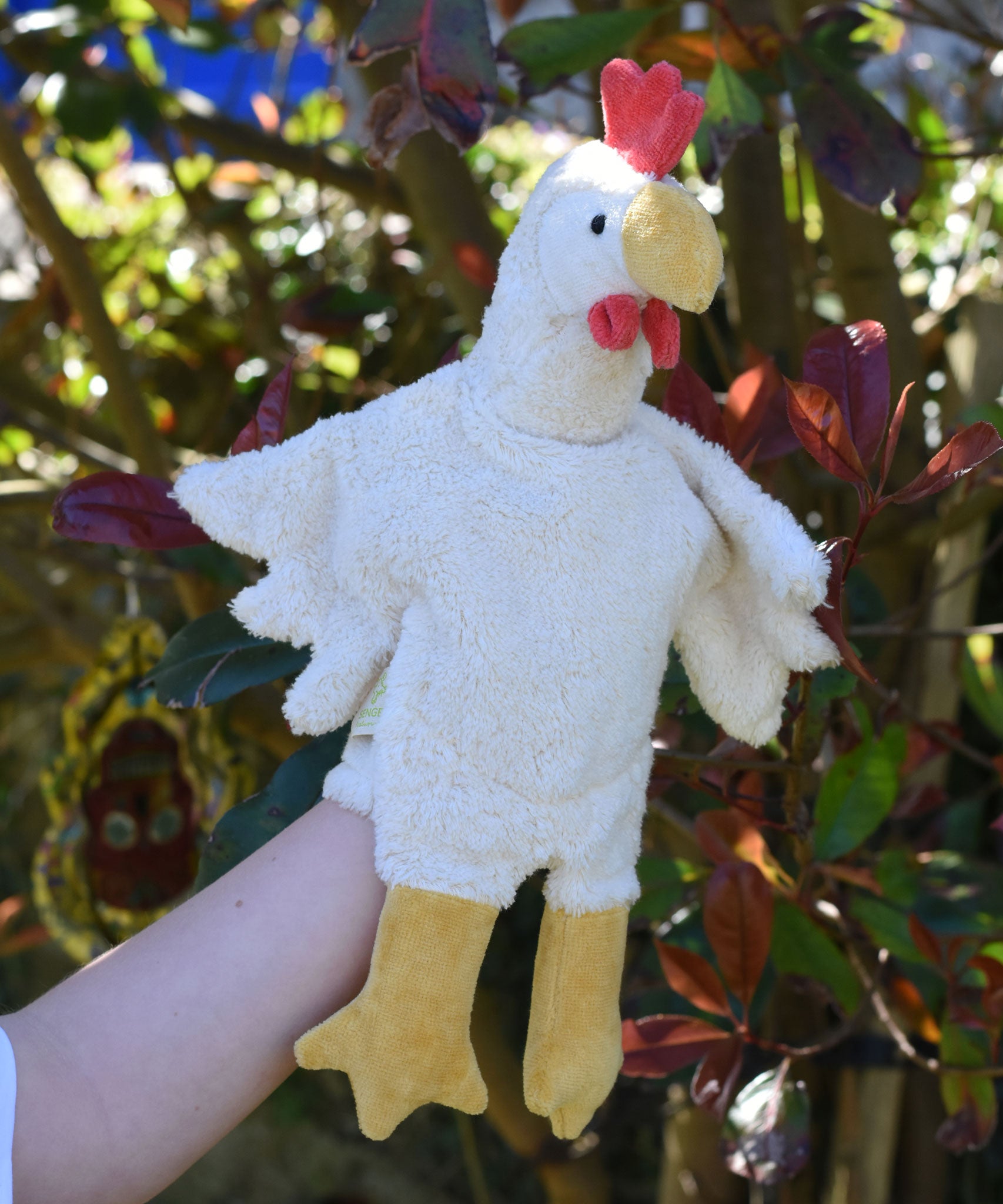 A close up of the Senger white chicken puppet in use on a child's hand.