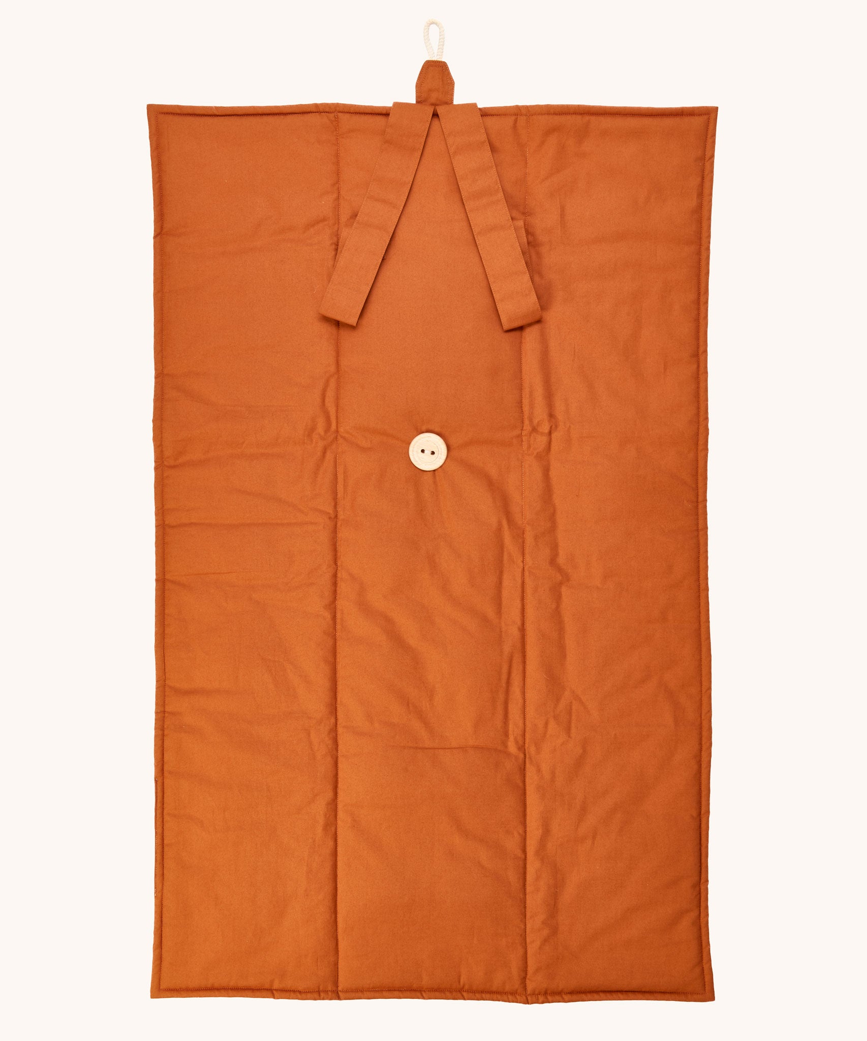 Senger cozy nap baby play mat. A padded blanket designed for babies to have a comfortable space whilst out and about. The dark orange coloured side has a button tat allows the mat to be rolled up for easy storage when not in use.