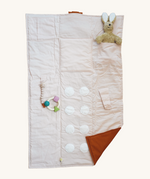 The Senger Cozy Nap playmat, with a Senger cuddly rabbit and a natural rubber teether attached to demonstrate how you can use it.