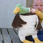 A child holding up a Senger Large Cuddly Drake Duck soft toy showing the white underside of the duck. 