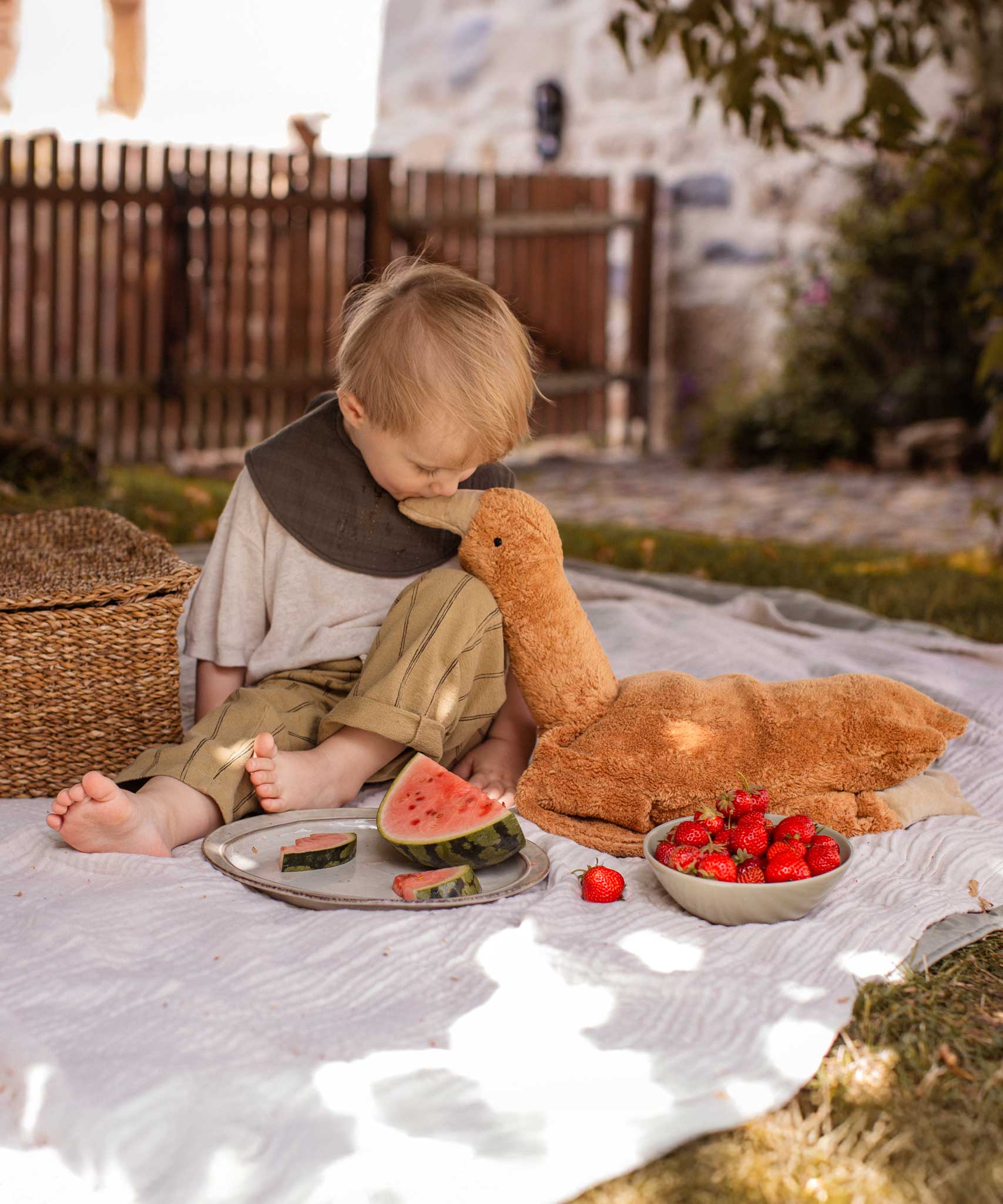 A child sitting next to a Senger Large Cuddly Goose organic soft toy in a dark orange Rust colour. These soft toys are created from the highest quality, sustainable and traceable natural materials. Senger cuddly animal toys and soft dolls are handmade in Germany with love and attention to detail and we are proud Senger stockists here at Babipur. 