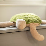 A large Senger Cuddly Green Turtle placed on a window sill. 