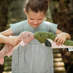 A little girls playing with two Senger cuddly fish organic stuffed toys