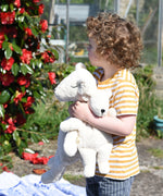 A little boy holding a mall and a large Senger organic cotton cuddly white teddy bear