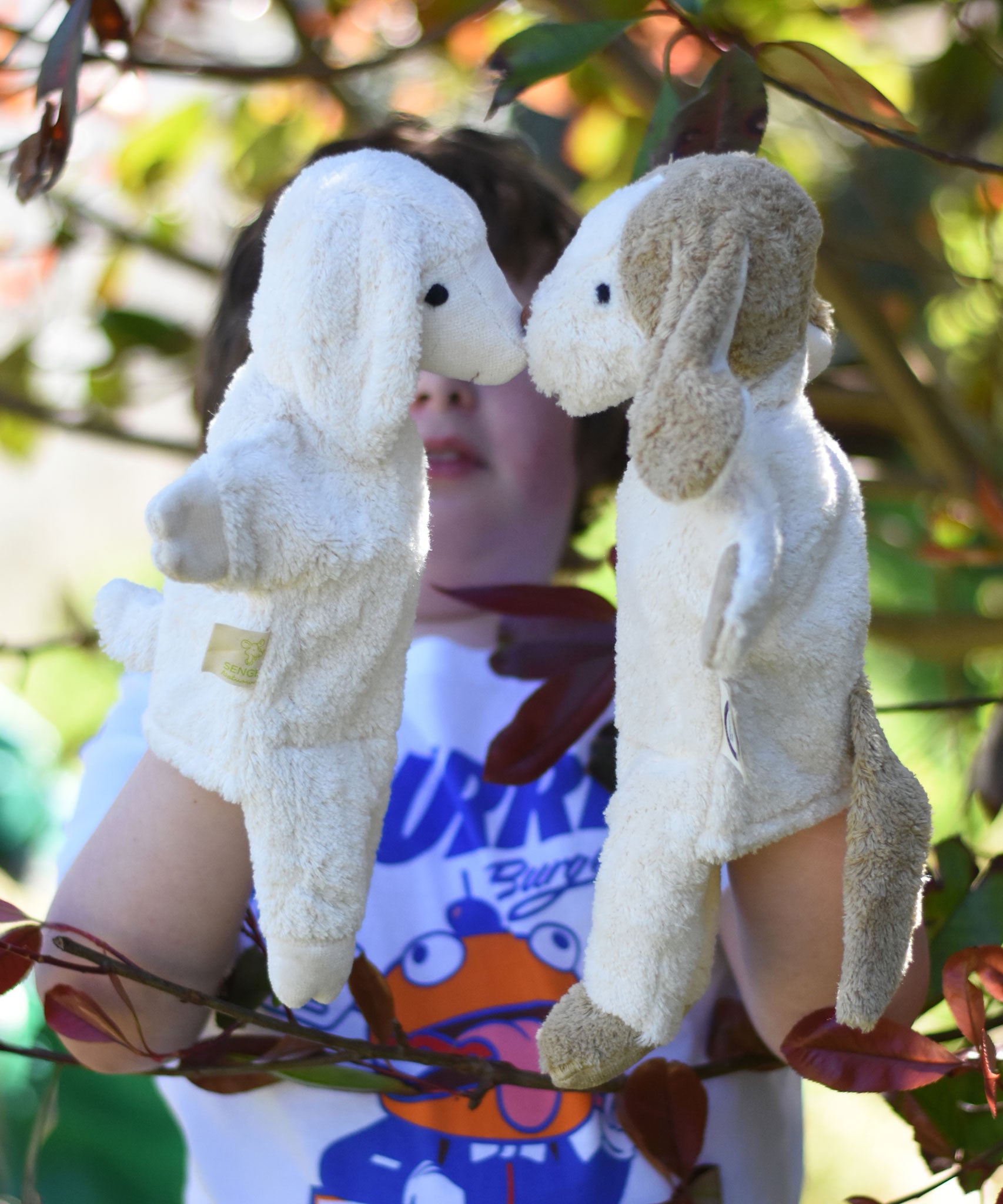 Senger dog and sheep puppet toys in use on a child's hands.