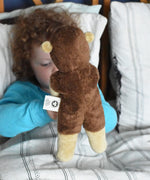 A child holding up the Senger small floppy hedgehog soft toy, a view of the back of the soft toy is shown to camera. The hedgehog is part of a wider selection of soft toys made with organic cotton and natural fillings that are available at Babipur. 